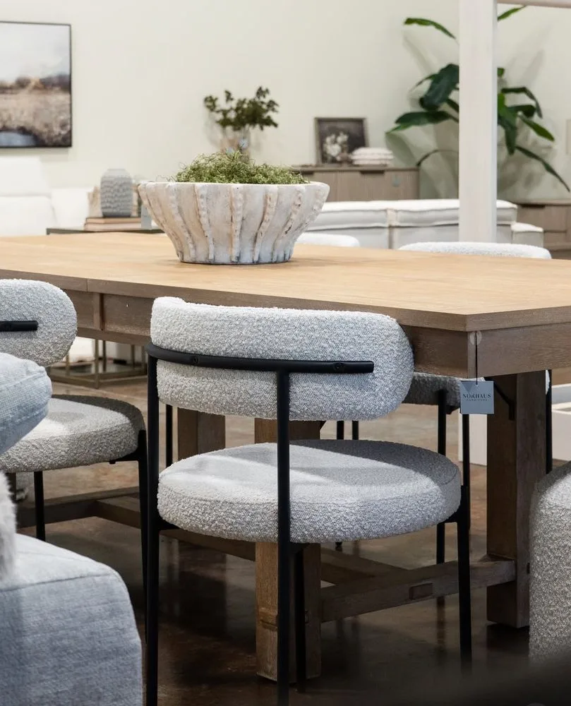 Natural wood dining table with textured upholstered chairs